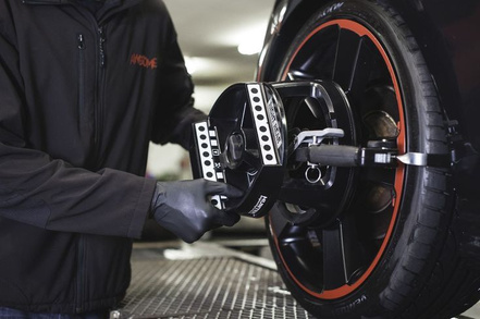 Technician attaching a wheel-alignment target to a car wheel